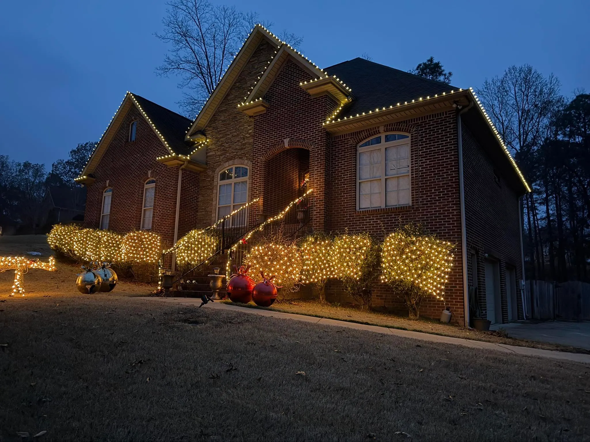 Brick home with warm lighting and yard decor