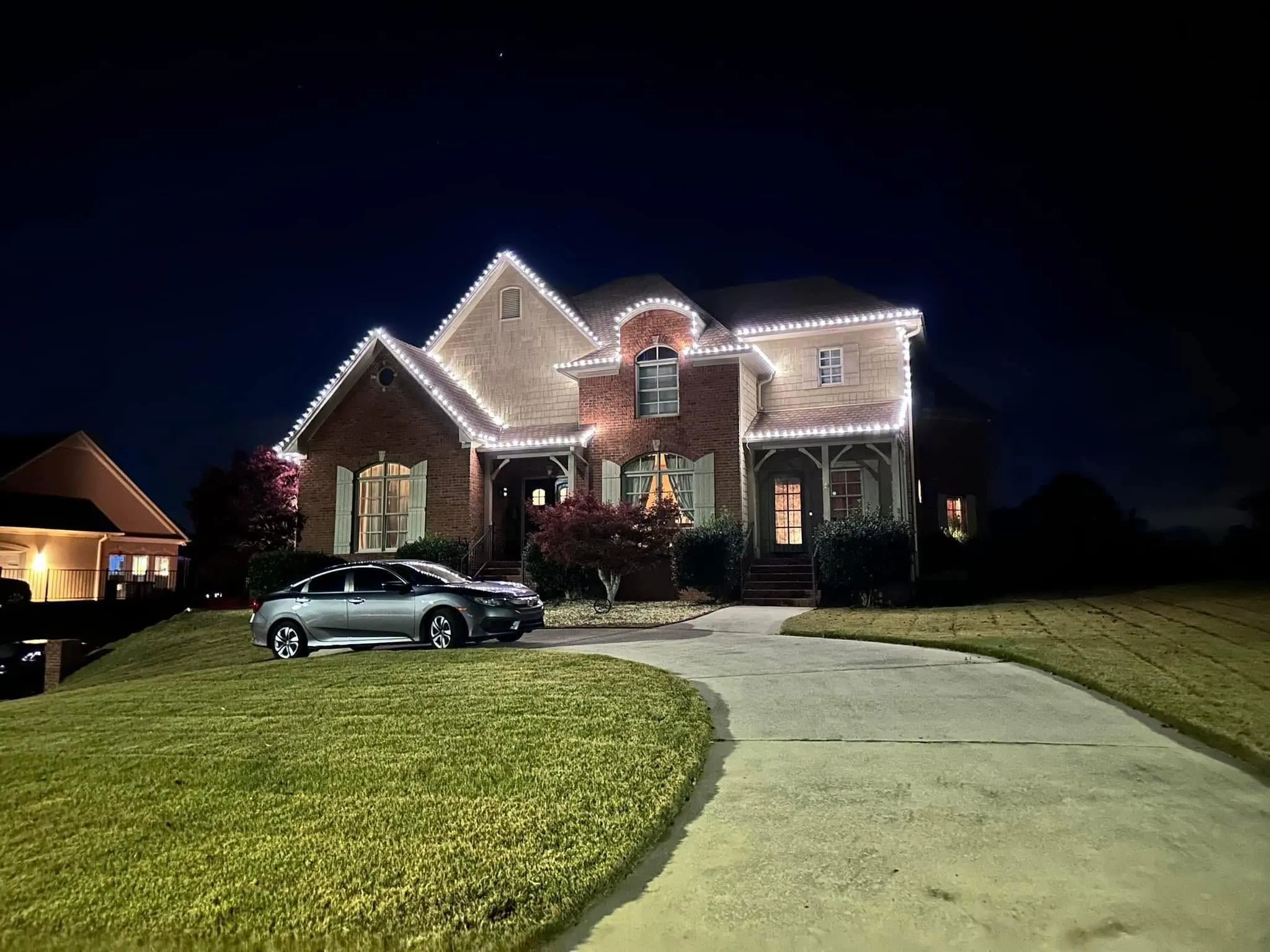 Home with Christmas roofline lighting at night